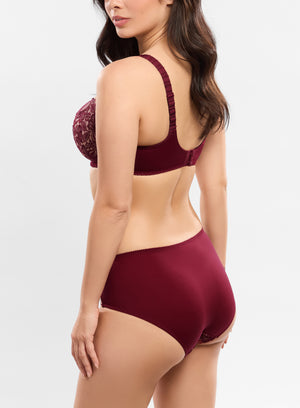 Woman wearing a burgundy lingerie set on a light gray background