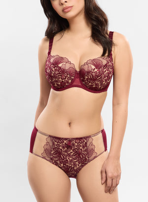 Woman wearing a burgundy lace lingerie set on a white background