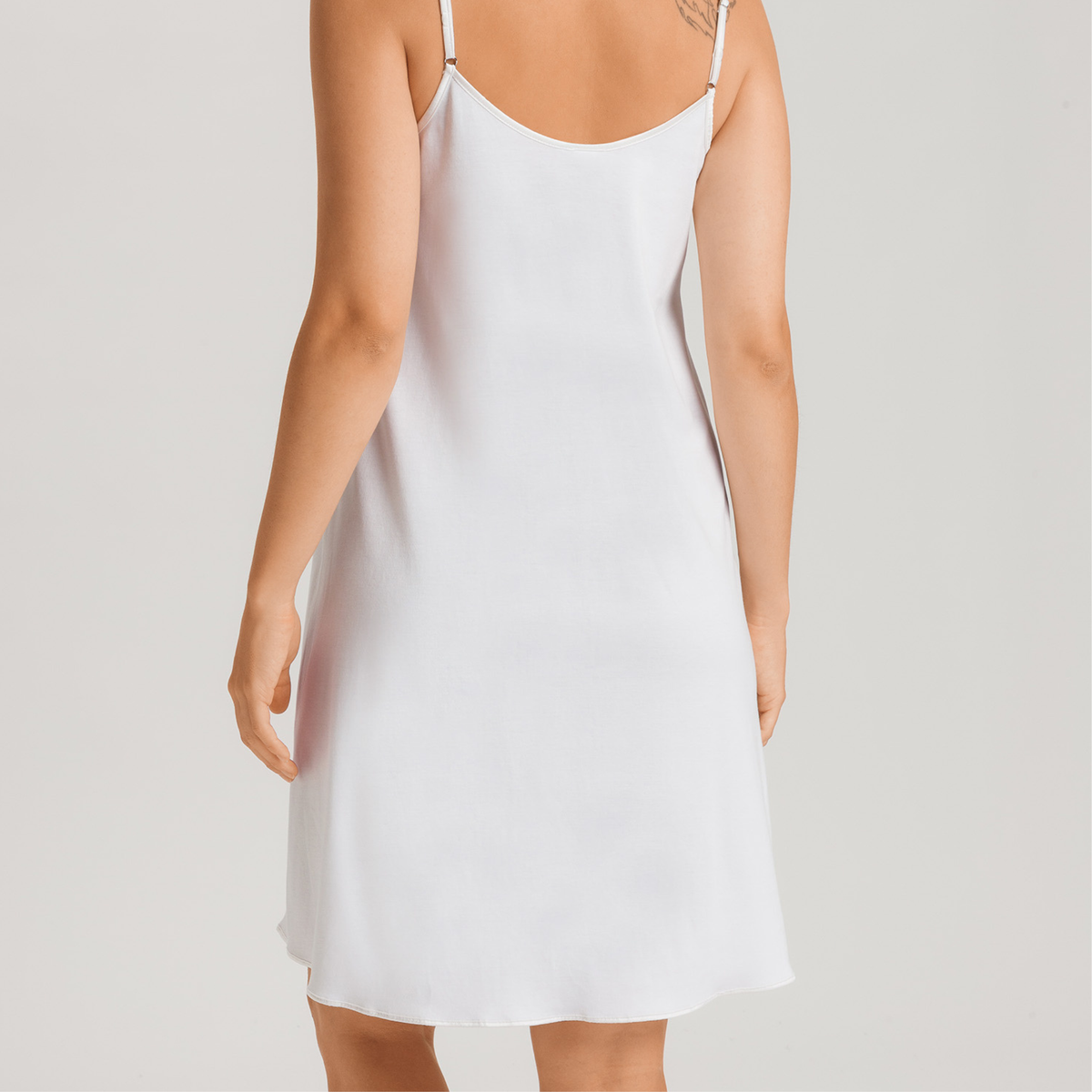 White slip dress worn by a person on a plain background