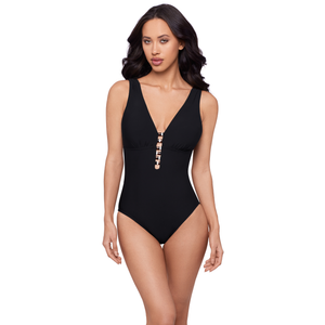 Woman wearing a black swimsuit with gold buttons on a white background