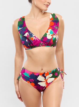 Woman wearing a colorful floral bikini set on a white background