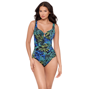 Woman wearing a blue and green floral one-piece swimsuit on a white background