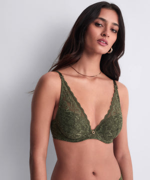 Woman wearing a green lace bra
against a plain background