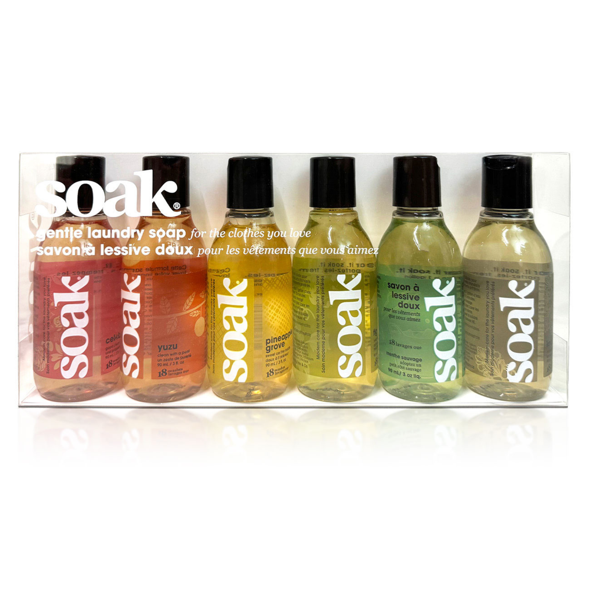 Set of six Soak laundry soap bottles in various colors on a white background