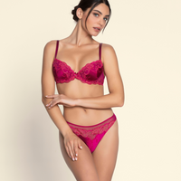Woman wearing a pink lace lingerie set on a beige background