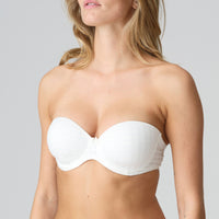 White strapless bra worn by a model on a gray background