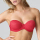 Red strapless bra worn by a model on a plain background