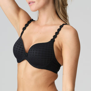 Black bra with floral details worn by a model on a plain background