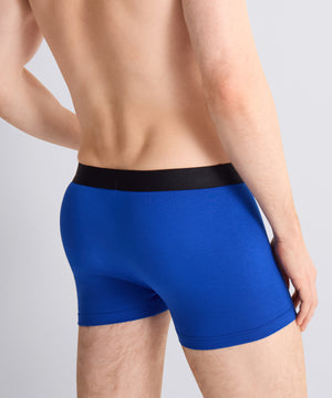 Blue boxer briefs with a black waistband on a gray background