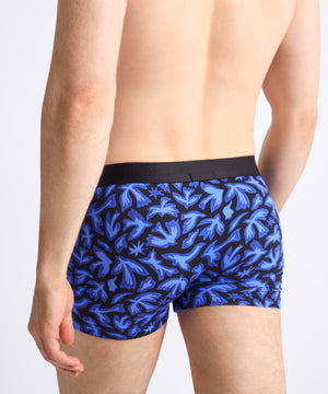 Blue patterned boxer briefs worn by a person on a light gray background